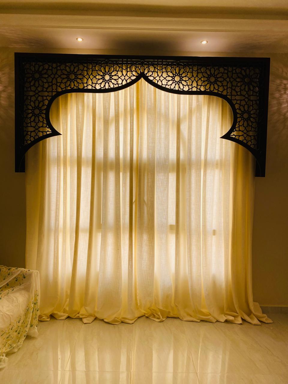 Sheer linen curtains beneath a carved pelmet